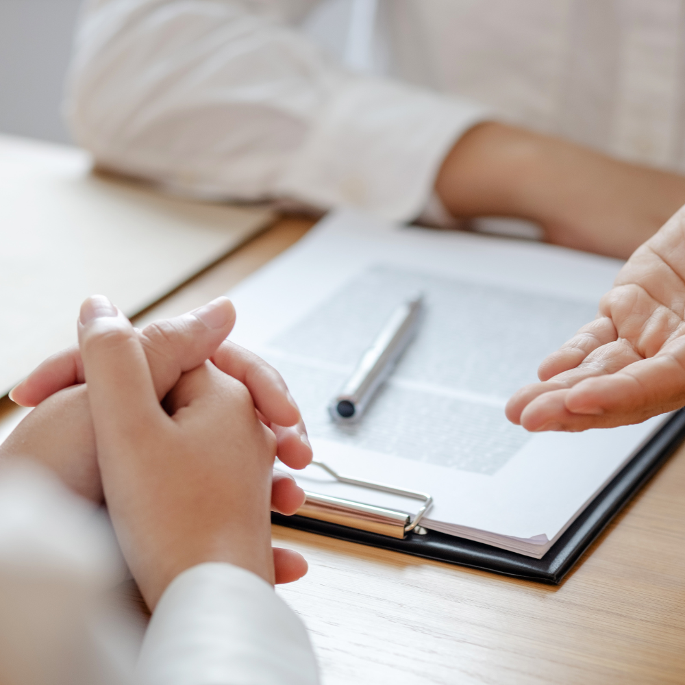 a close up of a legal document and the hands of two people discussing it.
